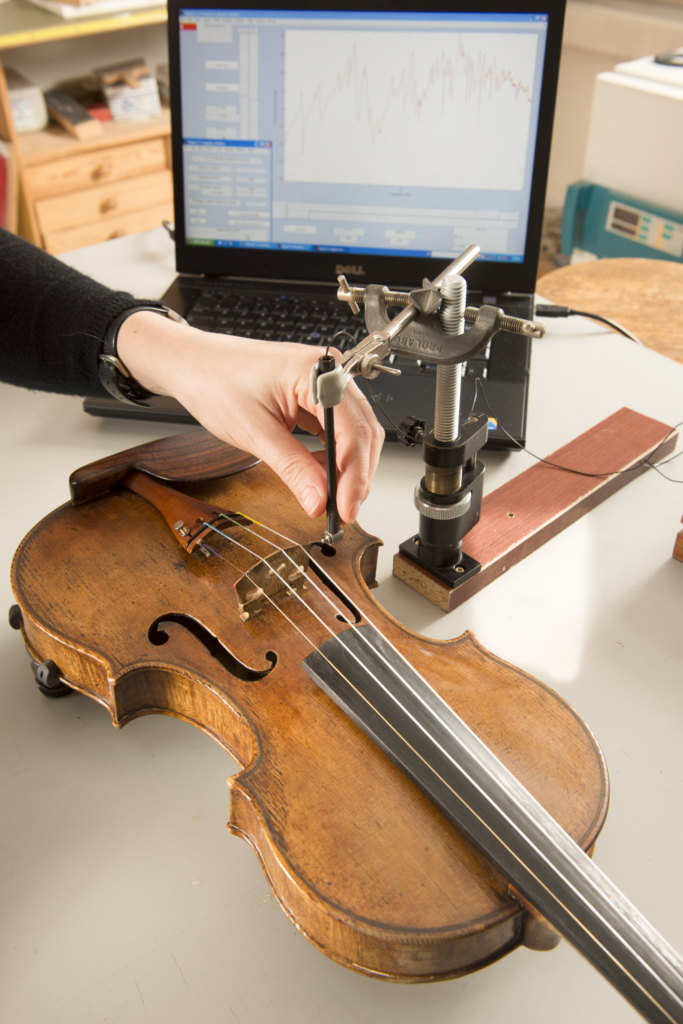 Reportage photographique: "Stradivarius, la fin de la legende". Institut Jean le Rond d'AlembertEquipe LAM(Lutheries - Acoustique - Musique) UPMC-CNRS. Claudia Fritz (Chargée de recherche CNRS en acoustique musicale). Mesures mécaniques sur des violons. La réponse vibratoire du violon est mesurée à l'aide d'un marteau d'impact miniature, qui excite le chevalet à un coin et d'un vibromètre laser enregistrant la vitesse de vibration du chevalet à son autre coin. Cette mesure caractérise partiellement le comportement vibratoire du violon, indépendamment du violoniste. L'objectif est d'étudier la qualité des violons, telle qu'elle est perçue par les violonistes et les auditeurs, pour la mettre ensuite en relation avec leurs propriétés vibratoires et acoustiques. EN: Institut Jean le Rond d'AlembertLAM Team. Claudia Fritz (Researcher in musical acoustic at CNRS) is measuring, using a hammer and a laser vibrometer        the vibrational behavior of the violin regardless of violinist. The goal is to study the quality of violins, as perceived by violinists and auditors, and put it in relation to their vibration and acoustic properties.