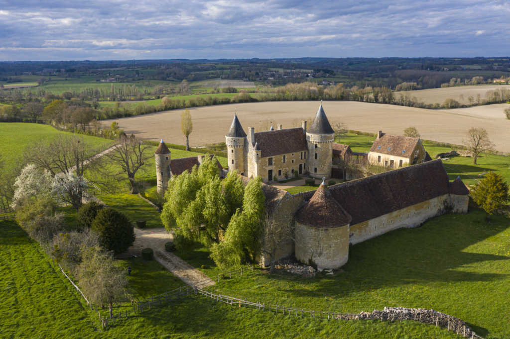 Le Manoir de l'Angenardière. Qu’il est imposant ce manoir. Au plus haut, le rempart culmine à huit mètres, sans autre ouverture que des fenêtres de tir. C’est une histoire de soldats et de combats qui s’est traduite ici. Son créateur, son inventeur, est Pierre de Fontenay. C’était l’un des hommes les plus puissants du Perche au moment de la Renaissance : gouverneur de la ville de Bellême et de son château ainsi que du comté du Perche, gentilhomme ordinaire de la chambre du roi. Pierre de Fontenay est aussi un guerrier. Il a bataillé sans relâche contre la ligue et pour le futur roi Henri IV. Il a fait le « bon choix » et en sera récompensé. Comblé d’honneurs, Fontenay se fait construire dans la vallée de la Rosière, à la fin du XVIe siècle, la plus jolie maison qui soit. Il dicte à l’architecte ses phantasmes d’homme de guerre. Meurtrières, mâchicoulis, échauguettes... tout y est. C’est un décor plus qu’autre chose. Mais quel effet ! Photographie extraite du projet photographique "les manoirs du Perche"